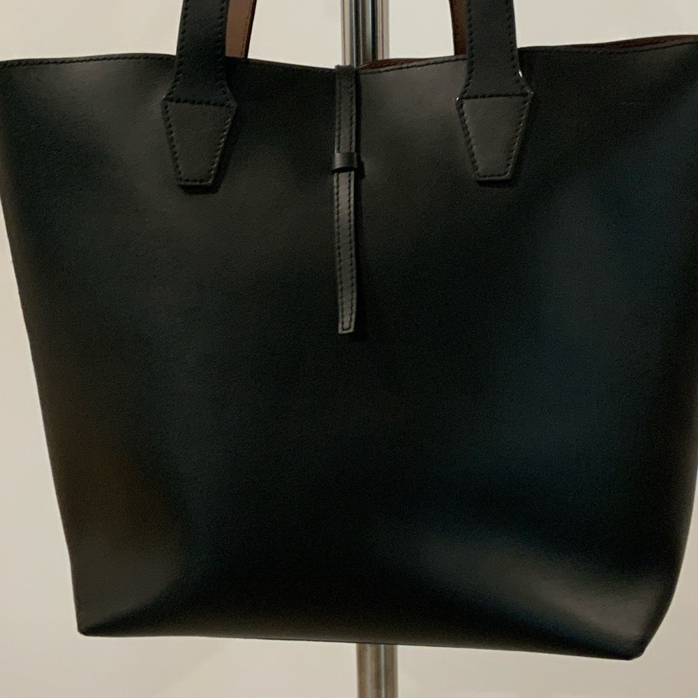 Elegant pleather tote bag. Brown interior. One zipper pocket inside.